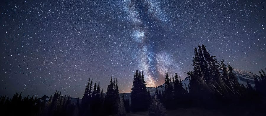 The Milky way galaxy and a shooting star over Mount Rainier in Washington State
