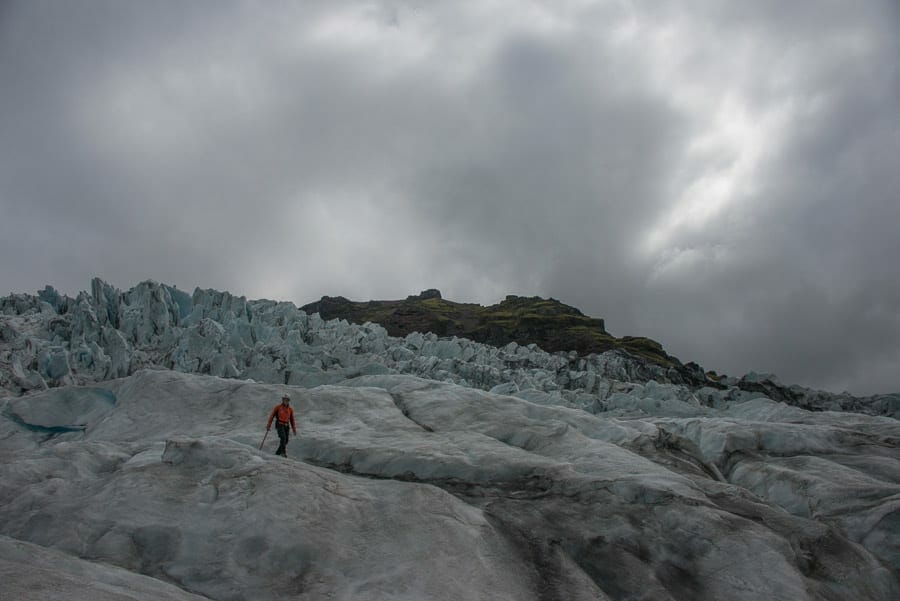 image showing man walking on glacier photographed on a cloudy day with a short shutter speed